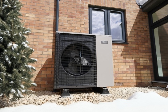 Ideal Logic Air heat pump unit installed outside in snowy conditions, showing professional installation in winter weather
